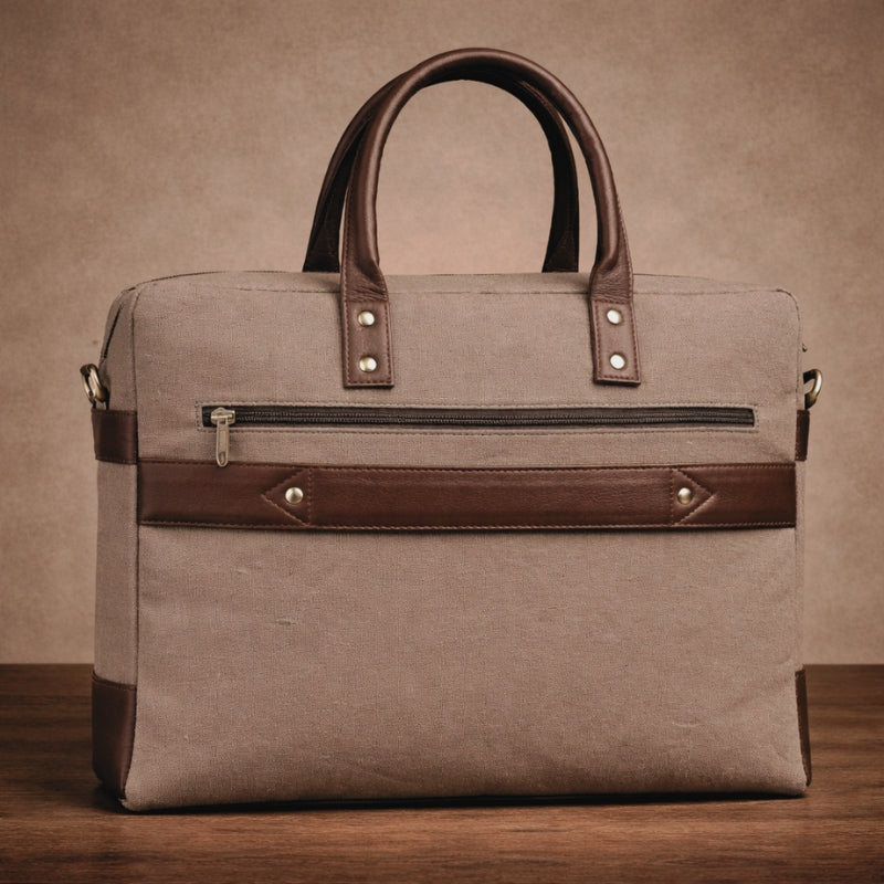 Brown leather and canvas handbag on a wooden surface with a brown background