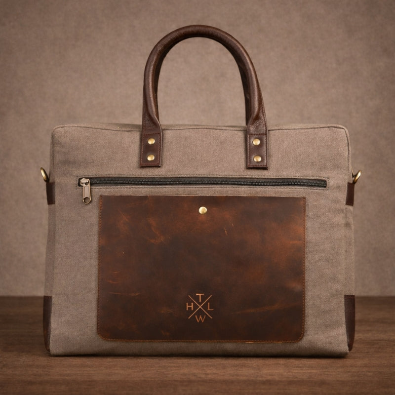 Brown leather and canvas briefcase with a visible brand logo on a brown background