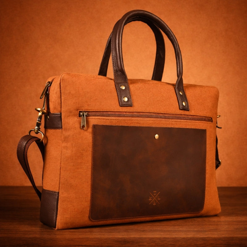 orange canvas & leather handbag with a visible brand logo on a wooden surface and brown background