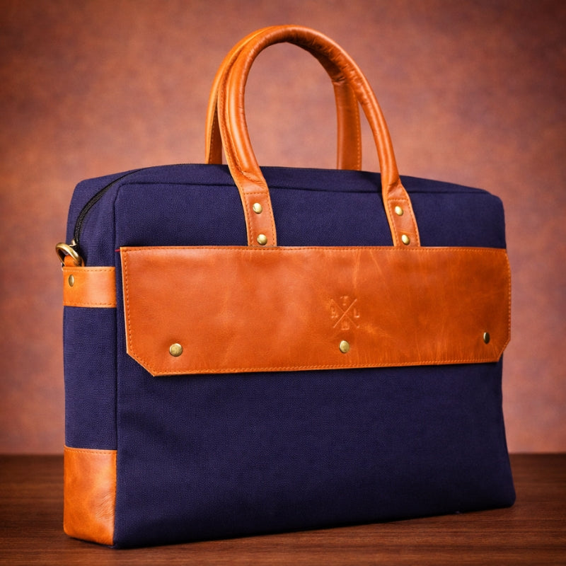 Navy blue bag with brown canvas accents on a wooden surface and brown background