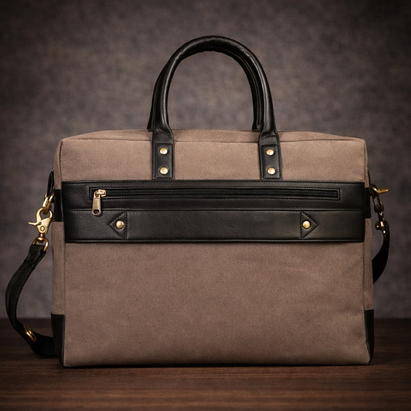 Brown canvas travel bag with black accents on a wooden surface and dark background