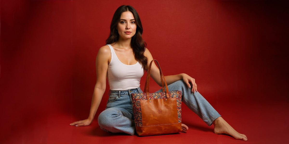 Woman holding a brown leather handbag against a red background