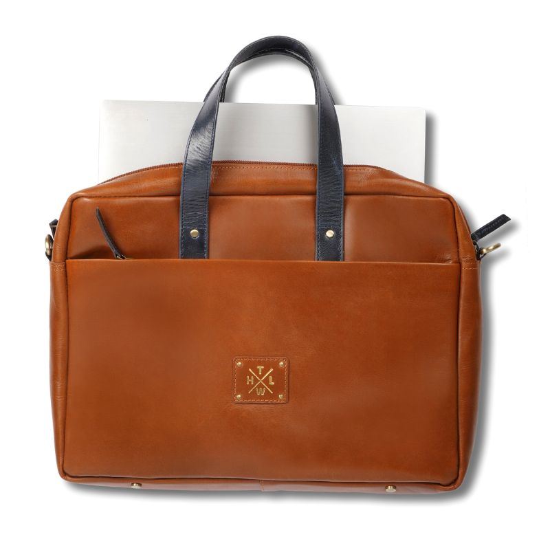 Tan leather bag with black handles on a white background