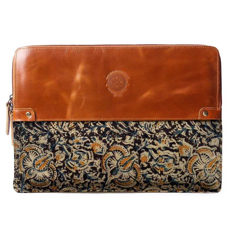 Leather and patterned fabric clutch bag on a white background