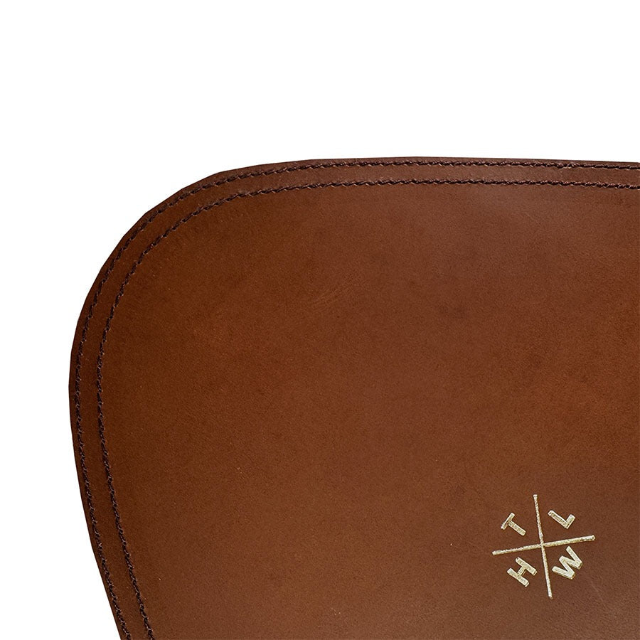 Close-up of a brown leather product with a logo on a white background