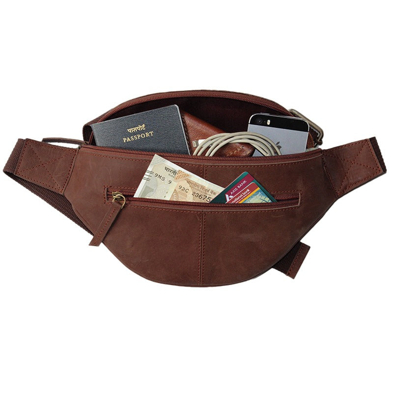 Brown waist bag with various items including a passport, cards, and phone on a white background