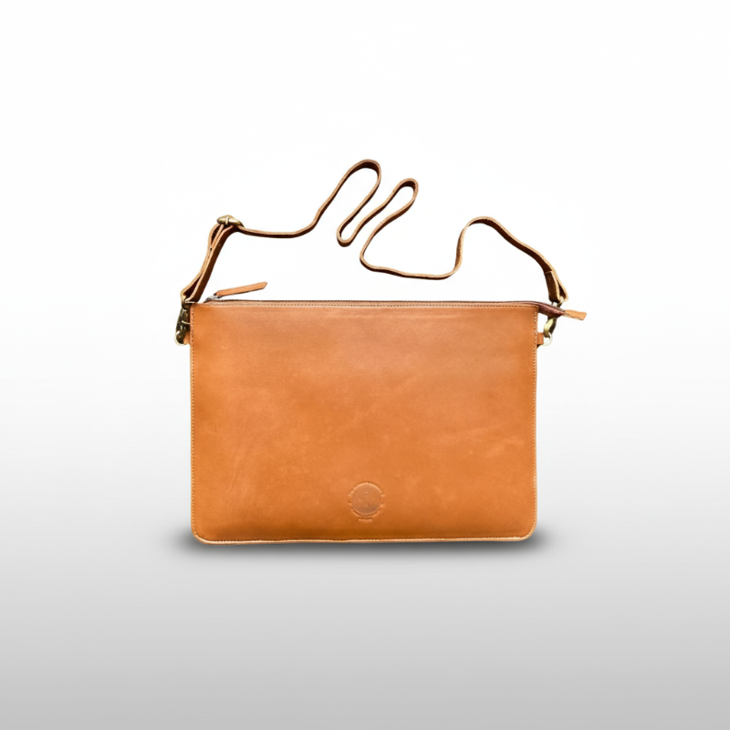 Brown leather handbag with gold handle on a light gray background