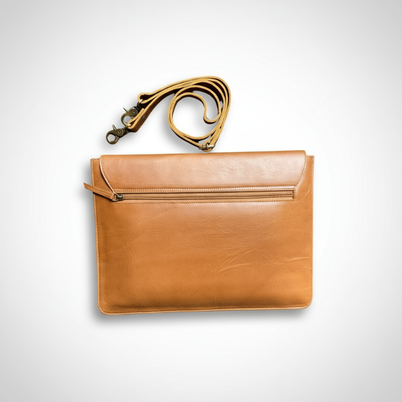 Tan leather clutch bag with a matching strap on a light gray background