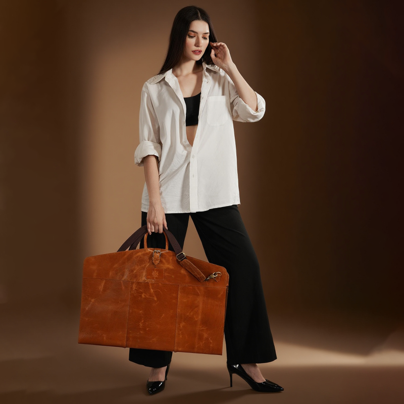 Woman holding a brown leather suitcase against a brown background