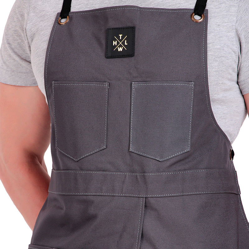 Person wearing gray apron with a brand logo on a white background