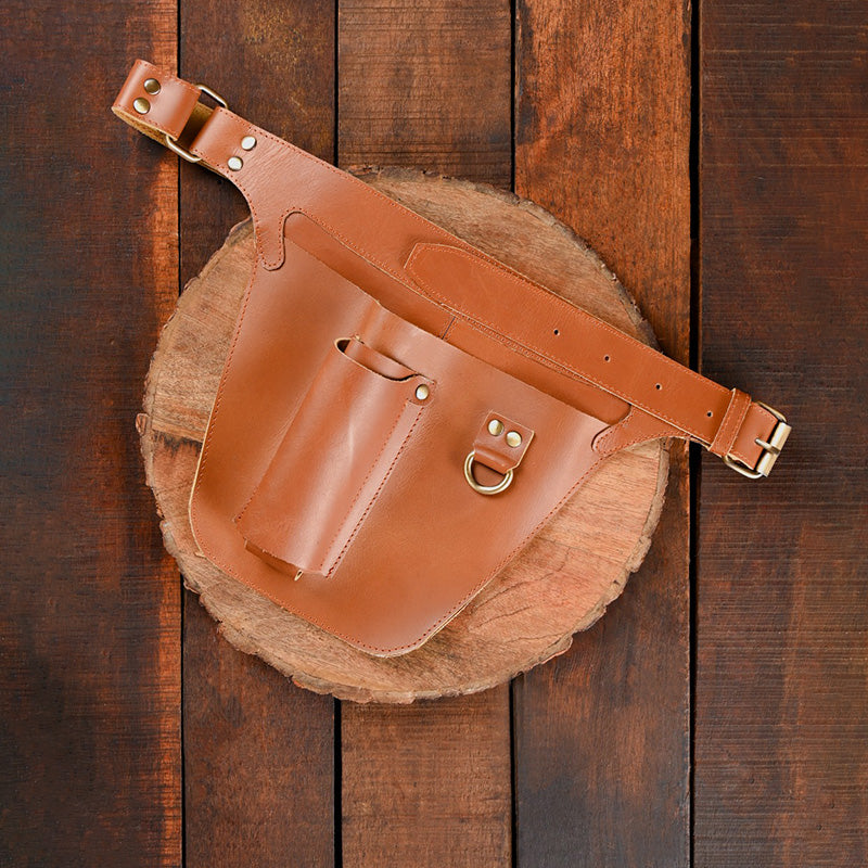 Brown leather belt bag on a wooden surface