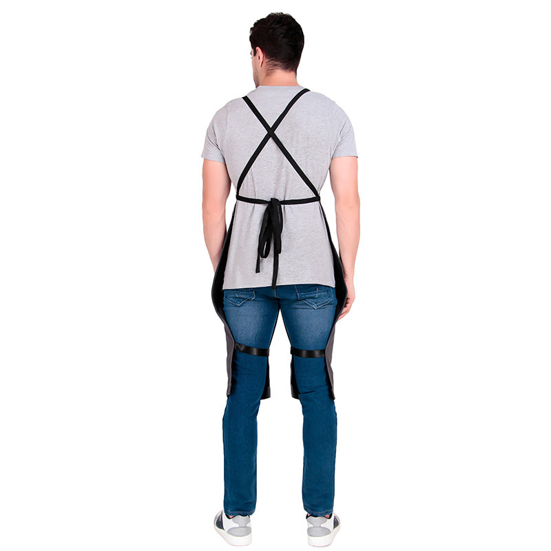 Person wearing a black apron with cross straps on a white background