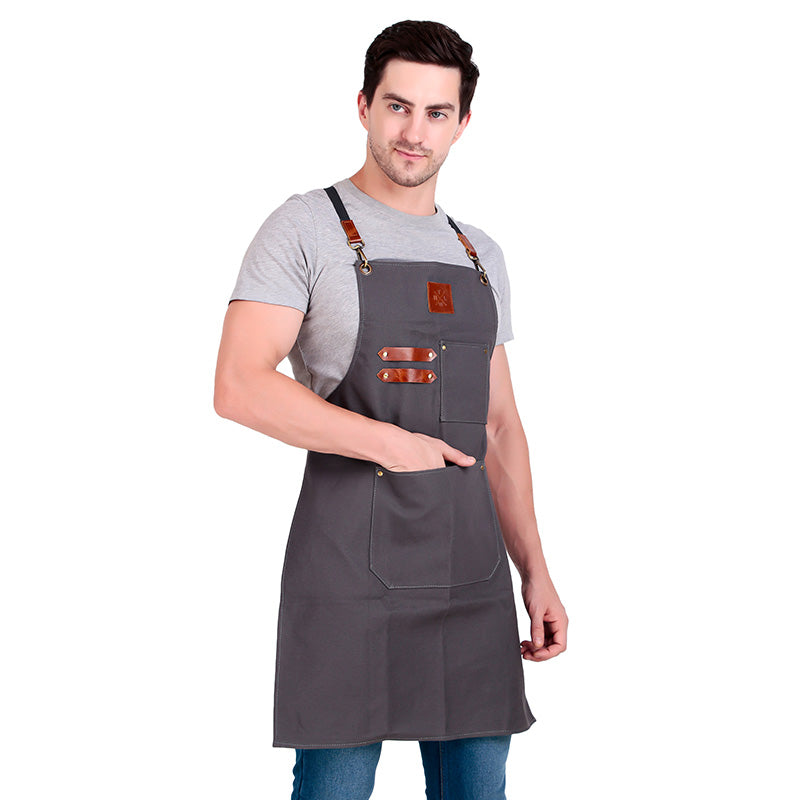Man wearing a gray apron with brown straps on a white background