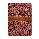 Notebook with red floral pattern and brown leather strap on a white background