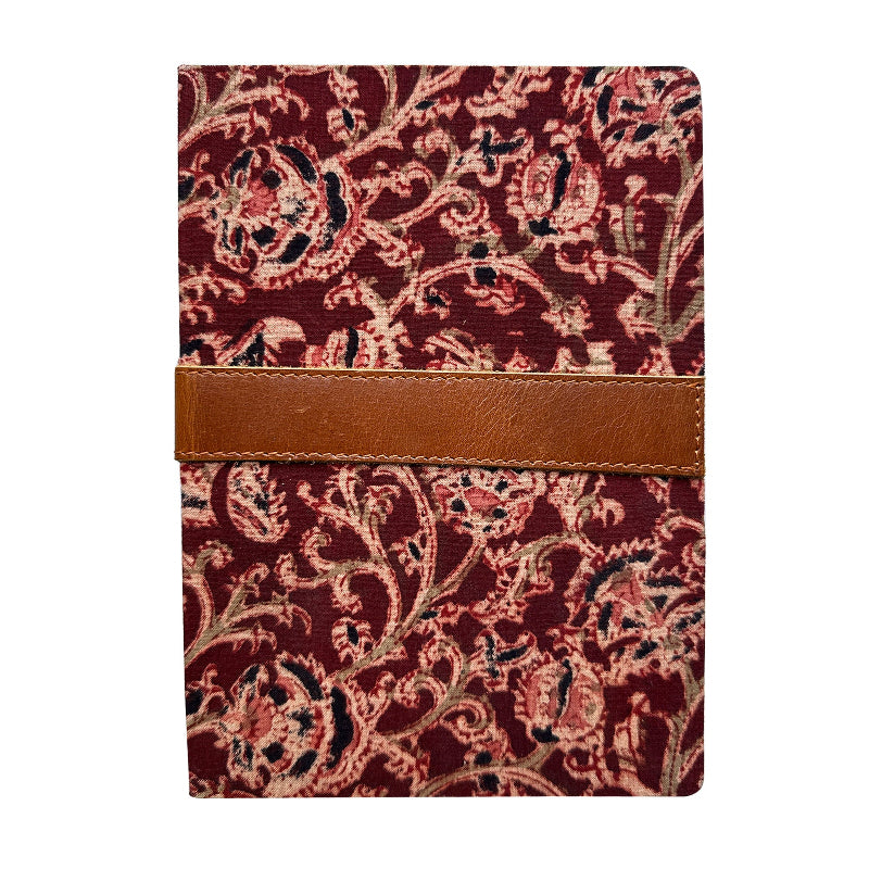 Notebook with red floral pattern and brown leather strap on a white background