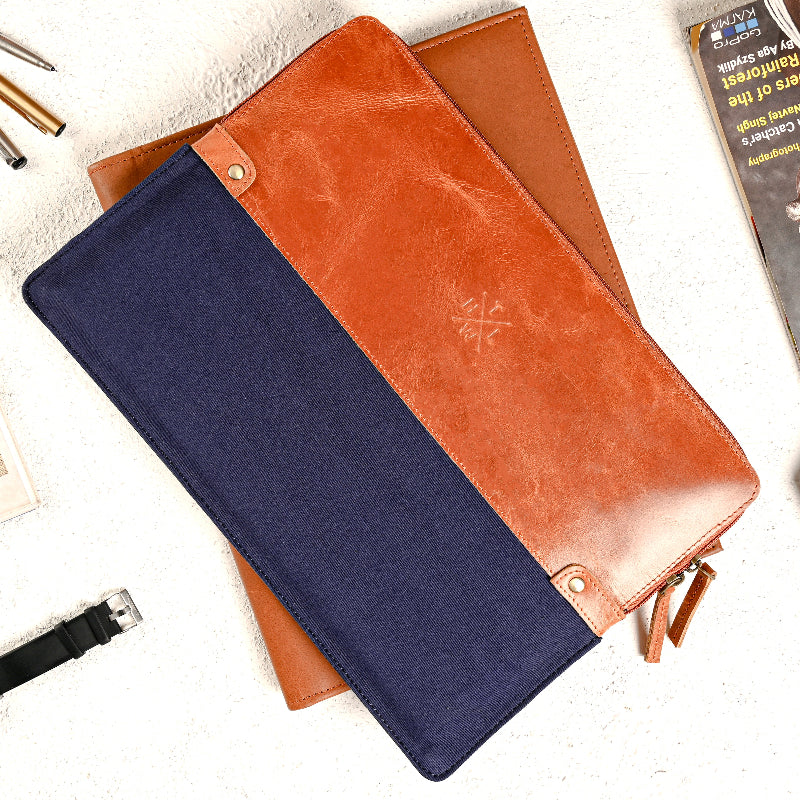 Two sleeve, one navy and one brown, on a white surface with accessories around.