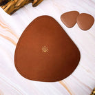 Brown leather placemat with a logo on a white surface
