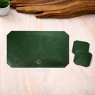Green leather placemat and coasters with a logo on a wooden surface