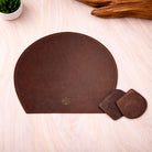 Brown leather mouse pad with two coasters on a light wooden surface.