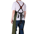 Person wearing a white shirt, green pants, and blue jeans with suspenders on a white background