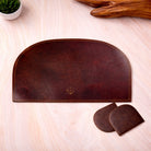 Brown leather desk set with coasters on a light wooden surface