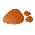 Set of three brown leather coasters on a white background