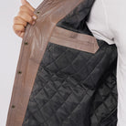 Close-up of a quilted jacket with a person wearing it, on a plain background