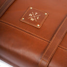Close-up of a brown leather product with a visible brand logo.