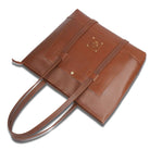 Brown leather handbag with a strap on a white background