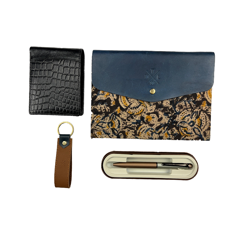 Collection of leather accessories including a black blue floral-patterned diary, wallet, brown keychain, and pen set on a white background.