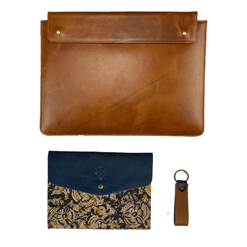 Collection of leather items including a brown leather sleeve, a blue kalmkari sleeve, and a brown keychain on a white background.