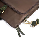 Chocolate Brown leather bag with green straps and gold hardware on a white background