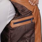 Close-up of a brown leather jacket with a zipper detail.