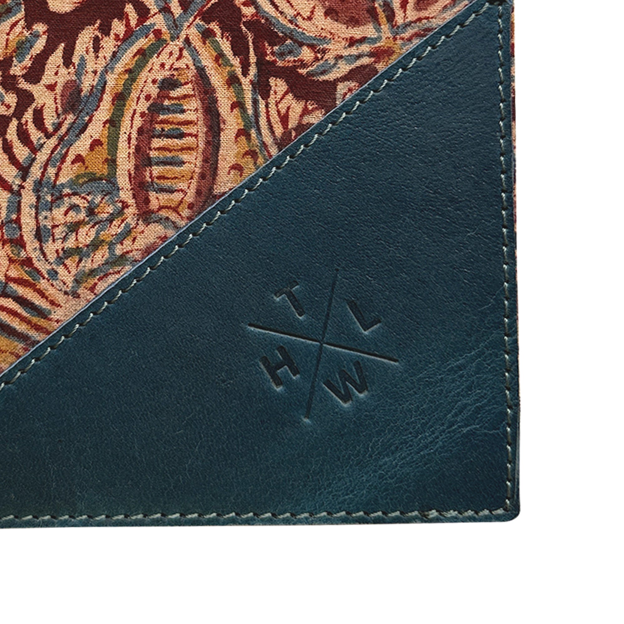 Corner of a product with a patterned fabric and embossed logo on a white background