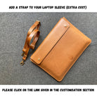 Brown leather laptop sleeve with an attached strap on a gray background
