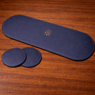 Navy blue eye placemat and coaster with a logo on a wooden surface