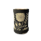 Black cylindrical container with gold floral pattern on a white background