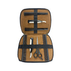 Set of grooming tools including scissors, razors, and combs in a brown case on a white background