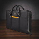 Black briefcase with a visible brand logo on a wooden surface and dark background