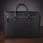 Black leather briefcase on a wooden surface with a dark background