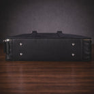 Black leather briefcase on a wooden surface with a dark background