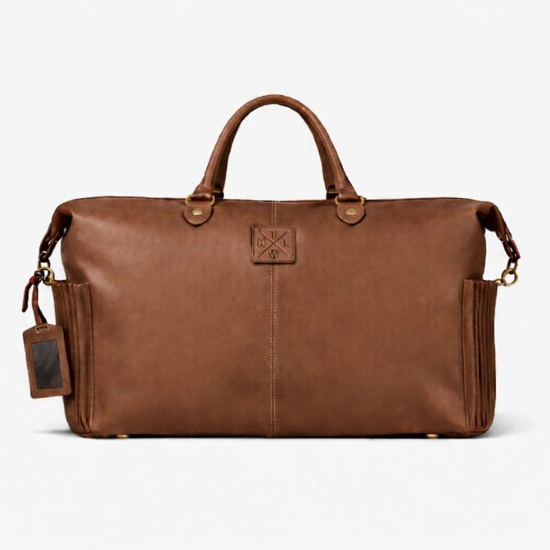 Brown leather duffel bag with a visible brand tag on a white background