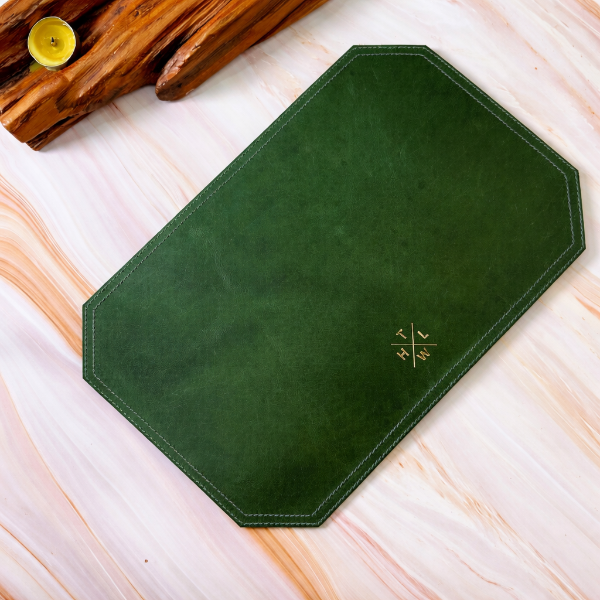 Green placemat with a logo on a light wooden surface