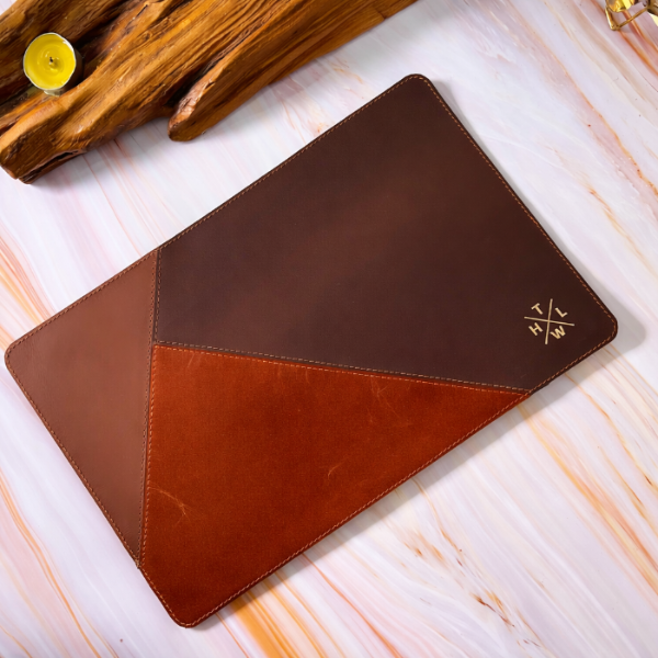 Brown leather mouse pad with geometric design on a light wooden surface