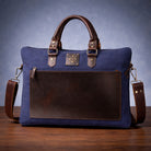 Blue and brown canvas & leather bag on a wooden surface with a blue gradient background