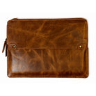 A brown distressed leather laptop sleeve with a front flap pocket, brass snap buttons, and a zipper closure, shown flat on a white background.