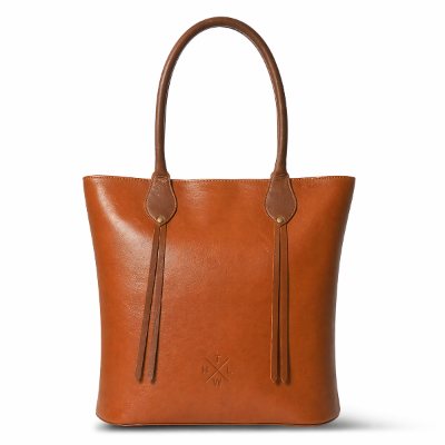 Brown leather tote bag with decorative straps on a white background