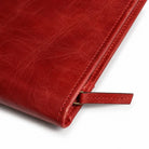 1. Close-up of red leather portfolio edge and leather zipper pull.