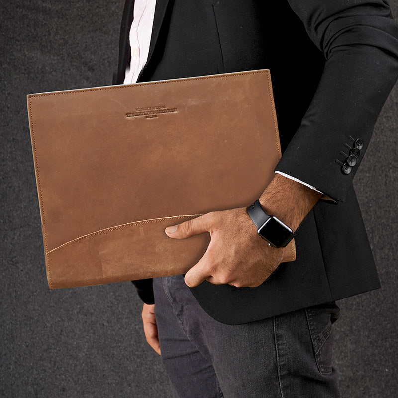 Premium brown leather file folder carried by a professional man