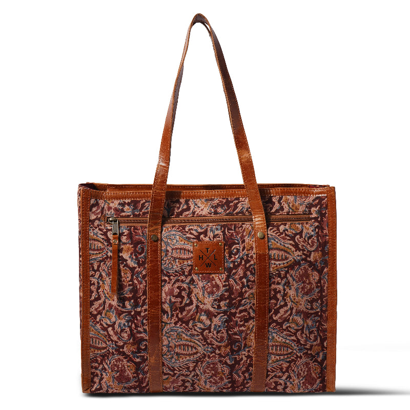 Brown tote bag with intricate pattern and visible brand logo on a white background